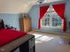 Bright bedroom featuring red curtains, a ceiling fan, and a view of the outdoor scenery at 2012 Silverleaf Dr, Youngsville, NC 27596