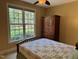 Inviting bedroom featuring a large window, a comfortable bed, and a wooden armoire at 2012 Silverleaf Dr, Youngsville, NC 27596