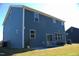 View of the backyard showcasing the blue siding, outdoor patio, and ample green space at 316 Robert Howe Dr, Fuquay Varina, NC 27526