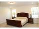 Spacious bedroom with a large bed, carpeted floors, and natural light from the two windows at 316 Robert Howe Dr, Fuquay Varina, NC 27526