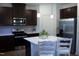 Well-lit kitchen featuring stainless steel appliances, dark wood cabinets, white countertops, and a functional center island at 316 Robert Howe Dr, Fuquay Varina, NC 27526