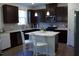 Modern kitchen featuring dark wood cabinets, stainless steel appliances, white quartz countertops, and a center island at 316 Robert Howe Dr, Fuquay Varina, NC 27526