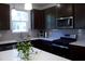Contemporary kitchen with stainless steel appliances, dark cabinets, quartz countertops, and sleek fixtures at 316 Robert Howe Dr, Fuquay Varina, NC 27526