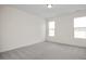 Spacious bedroom with grey carpeting and two large windows at 432 Old Fashioned Way, Lillington, NC 27546