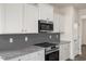 Modern kitchen with white cabinets, granite countertops and stainless steel appliances at 432 Old Fashioned Way, Lillington, NC 27546