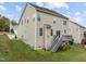 Rear view of a home with a wood deck and backyard, featuring neutral siding and multiple windows at 722 Redford Place Dr, Rolesville, NC 27571