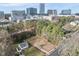 Aerial view of a vacant lot for sale in neighborhood with surrounding trees and city skyline in background at 216 Dartmouth Rd, Raleigh, NC 27609