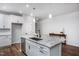 White kitchen with large island, granite countertops, and stainless steel appliances at 257 Circle City Way, Pittsboro, NC 27312