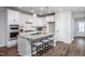 Modern kitchen features white cabinets, granite island, and stainless steel appliances at 257 Circle City Way, Pittsboro, NC 27312
