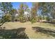 Large grassy backyard space with mature trees creating a natural and relaxing ambiance at 14 Stone Village Ct, Durham, NC 27704