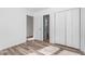 Bright bedroom featuring wood-look flooring, closet, and large windows at 14 Stone Village Ct, Durham, NC 27704