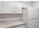 Clean kitchen space with white cabinets, countertops, and a full-size refrigerator at 14 Stone Village Ct, Durham, NC 27704