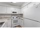 Bright kitchen with white appliances, cabinets and countertops featuring wood-look flooring at 14 Stone Village Ct, Durham, NC 27704