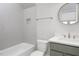 Modern bathroom featuring a tub with elegant tile and a stylish vanity with a round mirror at 20 Water Willow Ln, Zebulon, NC 27597
