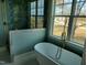 Elegant soaking tub with gold fixtures and a shower with glass doors next to large window at 20 Water Willow Ln, Zebulon, NC 27597