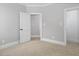 Bright bedroom with neutral walls, carpet floors, and a door leading to another room at 20 Water Willow Ln, Zebulon, NC 27597