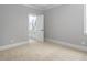 Bedroom with carpeted floors, neutral walls, and a doorway to a well-lit bathroom at 20 Water Willow Ln, Zebulon, NC 27597