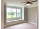Bedroom featuring a window seat beneath a large multi-pane window and ceiling fan at 20 Water Willow Ln, Zebulon, NC 27597