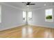 Spacious bedroom with hardwood floors, recessed lighting, neutral paint, and multiple large windows at 20 Water Willow Ln, Zebulon, NC 27597