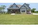 Charming home features a covered porch, manicured lawn, and stone accents, with a welcoming entrance at 20 Water Willow Ln, Zebulon, NC 27597