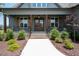 Inviting front entrance featuring a wooden door, sturdy porch columns, and wrought iron railings at 20 Water Willow Ln, Zebulon, NC 27597