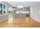 Open-concept kitchen with a central island, stainless appliances, and a view of the backyard through sliding glass doors at 20 Water Willow Ln, Zebulon, NC 27597
