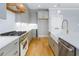 Gourmet kitchen with stainless steel appliances, gas range, wooden vent hood and hardwood floors at 20 Water Willow Ln, Zebulon, NC 27597