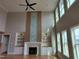 Elegant living room with high ceilings, large windows, and a stylish fireplace with built-in shelving and cabinets at 20 Water Willow Ln, Zebulon, NC 27597