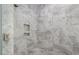 Luxurious walk-in shower with marble tile and built-in shelving at 20 Water Willow Ln, Zebulon, NC 27597