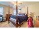 Primary bedroom featuring four poster bed, ceiling fan and view of side yard at 229 Rose Walk Ln, Carrboro, NC 27510