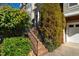 A brick staircase with black iron railings leads to a covered front entrance, framed by lush greenery at 229 Rose Walk Ln, Carrboro, NC 27510