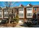 Charming brick townhome with attached garage, landscaped front yard, and a clear blue sky overhead at 229 Rose Walk Ln, Carrboro, NC 27510