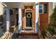 Inviting brick entryway with black door adorned with a wreath, black railings, and hanging lanterns at 229 Rose Walk Ln, Carrboro, NC 27510