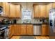 Kitchen features stainless steel appliances, light wood cabinets, tiled backsplash, and black counters at 229 Rose Walk Ln, Carrboro, NC 27510
