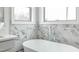 Elegant bathroom featuring soaking tub and white marble tiling at 2401 Terri Creek N Dr # 08, Fuquay Varina, NC 27526