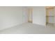 Clean, carpeted bedroom with white walls and trim, featuring an open closet and doorway at 2401 Terri Creek N Dr # 08, Fuquay Varina, NC 27526