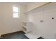 Bright laundry room boasts black tile floor, built-in shelving, and washer/dryer hookups at 2401 Terri Creek N Dr # 08, Fuquay Varina, NC 27526