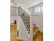 Staircase with hardwood treads and iron balusters connecting two stories, with kitchen view at 2401 Terri Creek N Dr # 08, Fuquay Varina, NC 27526