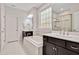 Bright bathroom featuring a soaking tub, shower, and double vanity with dark wood cabinetry and white countertops at 2618 Needle Pine Dr, Apex, NC 27539