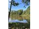 This property boasts a serene pond surrounded by lush greenery and a clear blue sky at 3101 Sawyers Mill Dr, Apex, NC 27539