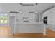 Modern kitchen with white cabinets, quartz countertops, and a large island with pendant lighting at 5100 Grist Stone Way, Youngsville, NC 27596
