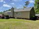 Backyard view featuring a deck, mature trees, and well-maintained lawn at 6220 Sweden Dr, Raleigh, NC 27612
