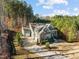 An aerial view of a house with an attached garage and a long driveway, surrounded by tall trees at 181 Colonial Ridge Dr, Pittsboro, NC 27312