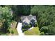 Aerial view of a home surrounded by lush greenery, showcasing the well-maintained lawn and long driveway at 181 Colonial Ridge Dr, Pittsboro, NC 27312