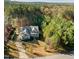 Aerial view of a home with a long driveway, a 3-car garage, and surrounded by dense trees at 181 Colonial Ridge Dr, Pittsboro, NC 27312