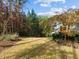 Wide shot showing the tree-lined backyard with various plants and shrubbery at 181 Colonial Ridge Dr, Pittsboro, NC 27312