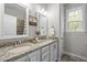 Bathroom with double sink vanity, granite countertop, framed mirrors, and elegant lighting fixtures at 181 Colonial Ridge Dr, Pittsboro, NC 27312