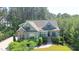 Inviting home featuring charming curb appeal with lush landscaping, brick accents, and an open front porch at 181 Colonial Ridge Dr, Pittsboro, NC 27312