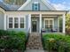 Inviting front porch featuring white columns with stone steps and mature plantings at 181 Colonial Ridge Dr, Pittsboro, NC 27312