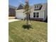 Inviting home featuring stone accents, a well manicured lawn, and a cozy dormer window above the entrance at 579 Winding Creek Dr, Lillington, NC 27546